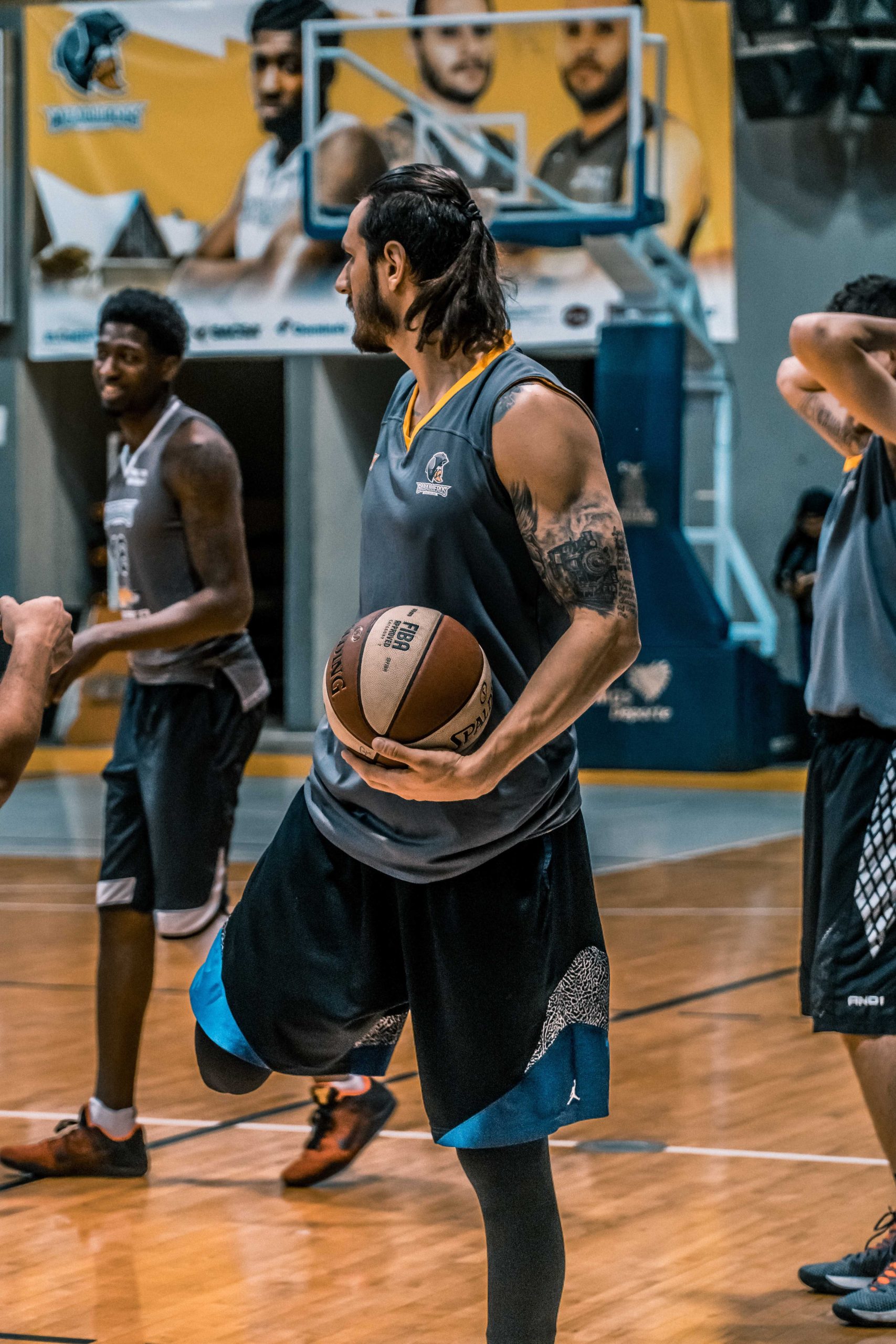 Free Man in Gray Sleeveless Shirt Carrying White and Brown Spalding Basketball Stock Photo